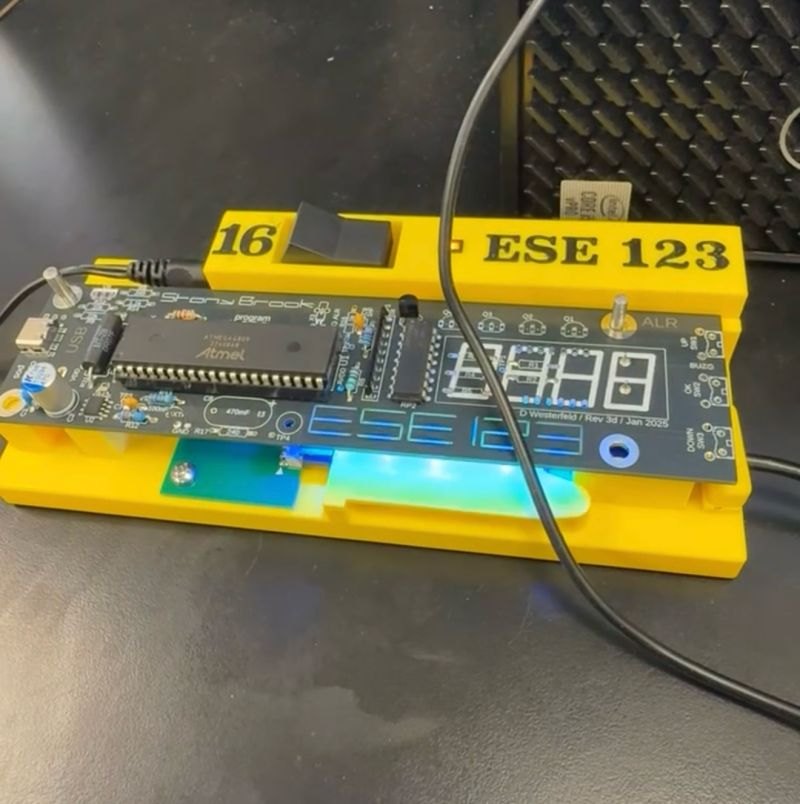 The clock's circuit board in the ESE 123 lab fixture, with the ATmega4809 and seven-segment display